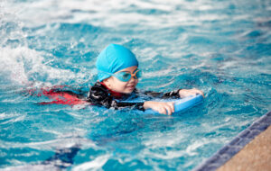 Boy swimming in a pool on floatation devoce